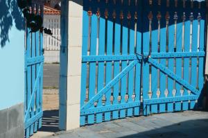 niebieską bramą przed budynkiem w obiekcie Casa de Praia em Mongaguá w mieście Mongaguá