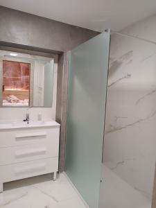 biała łazienka z umywalką i prysznicem w obiekcie Hostal Platerías w mieście León