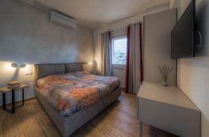 a small bedroom with a bed and a window at Casa Adelina nel Centro dei Sassi in Matera