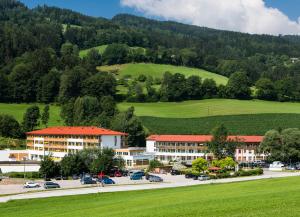 a resort with a green hill in the background at Gesundheits- & Wellness Resort Weissenbach 