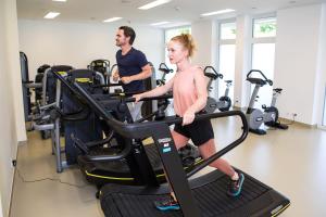un hombre y una mujer en una cinta de correr en un gimnasio en Gesundheits- & Wellness Resort Weissenbach, 