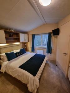 a bedroom with a large bed and a window at moonflower lodge in Newton on the Moor