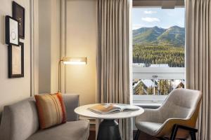 a hotel room with a table and chairs and a window at Fairmont Banff Springs in Banff