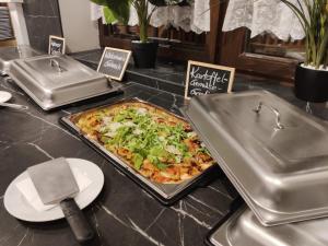 een pizza bovenop een aanrecht naast een tafel bij Landhotel Mariensäule in Wernstein am Inn