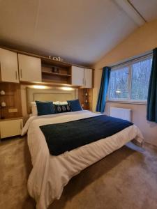 a bedroom with a large bed and a window at moonflower lodge in Newton on the Moor