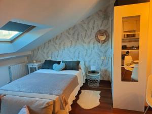 1 dormitorio con 1 cama con pared azul en El Cielo de Fomento, en Gijón