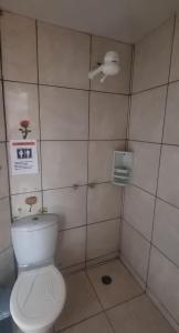 a bathroom with a toilet and a sign on the wall at Suites Solar dos Arcanjos Guaramiranga in Guaramiranga