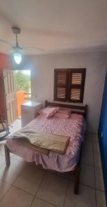 a bedroom with a bed with a wooden head board at Suites Solar dos Arcanjos Guaramiranga in Guaramiranga