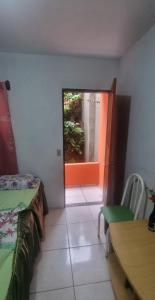 a room with a room with a window and a table at Suites Solar dos Arcanjos Guaramiranga in Guaramiranga