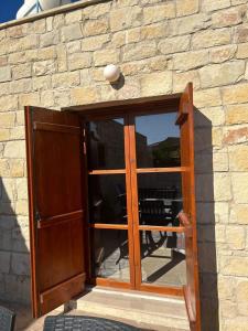 a wooden door with a window in a stone wall at Fontana Traditional House in Anarita