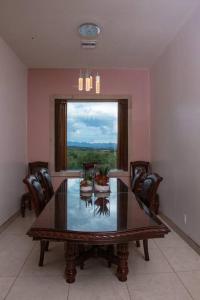 a dining room with a table and chairs and a window at Casa de campo con vistas espectaculares in Nogales