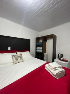 a bedroom with a large bed with a red blanket at Entre serra pousada de altitudes in Urubici
