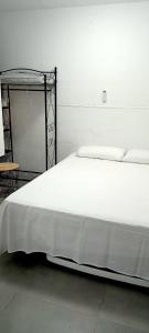 a large white bed with a metal frame in a room at Old Center Inn Alicante in Alicante