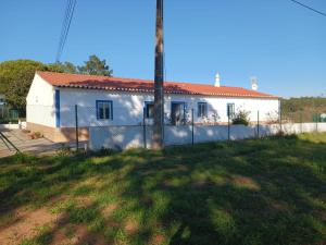 a white house with a fence in a yard at Quinta do Pinhal Novo in Chabouco