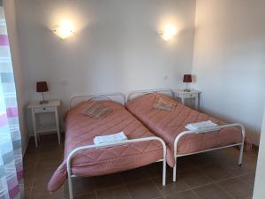 a bedroom with two beds with pink sheets at Quinta do Pinhal Novo in Chabouco