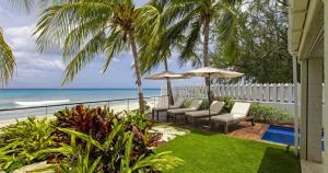 um pátio com cadeiras e guarda-sóis com vista para o oceano em Radwood 2 by Barbados Sothebys International Realty em Saint James