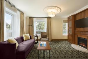 a living room with a couch and a fireplace at Fairmont Banff Springs in Banff