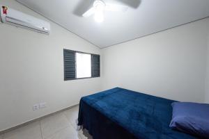 a white room with a bed and a window at Jahu Center Casas Un 1 in Jaú