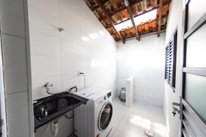 a small bathroom with a washing machine and a sink at Jahu Center Casas Un 1 in Jaú