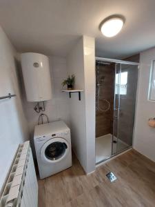 a bathroom with a washing machine and a shower at The Golden Well in Rovinj