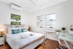 sypialnia z łóżkiem, biurkiem i oknami w obiekcie Kiki, 6 mins to Cairns and Airport, pet friendly w mieście Cairns North