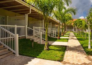 una casa con una valla blanca y palmeras en Bella Terra Laguna Azul Resort & Spa en Sauce