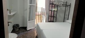 - une chambre avec un lit et une porte donnant sur un balcon dans l'établissement Old Center Inn Alicante, à Alicante