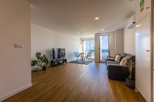 uma sala de estar com um sofá e uma televisão em Mare Nostrum Apartment em Ponta Delgada