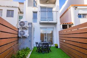 um pátio com mesa e cadeiras em um prédio em Mare Nostrum Apartment em Ponta Delgada