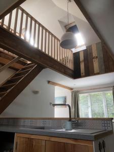 a kitchen with a sink and a wooden staircase at Cosy Rustic Annex in quiet Cornwall Village in Saint Wenn