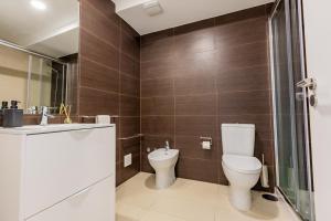 um banheiro com vaso sanitário, pia e chuveiro em Mare Nostrum Apartment em Ponta Delgada mais 15 fotografias