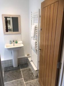 a bathroom with a sink and a mirror at Cosy Rustic Annex in quiet Cornwall Village in Saint Wenn