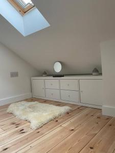 a white room with a white dresser and a rug at Cosy Rustic Annex in quiet Cornwall Village in Saint Wenn