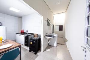 a small kitchen with a sink and a stove at Jahu Center Casas Un 1 in Jaú +82 photos