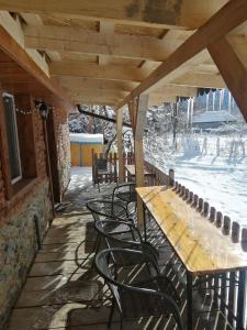 einen Holztisch und Stühle auf einer Terrasse in der Unterkunft Borlova /Muntele Mic in Borlova