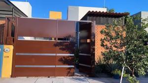 a building with a brown door and a tree at Casa totalmente nueva in Colima