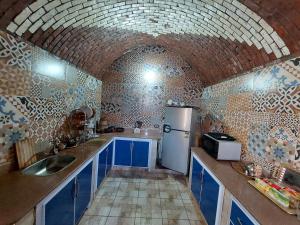 a kitchen with blue cabinets and a white refrigerator at Mostafa Nubian Guesthouse in Najâ€˜ al MadÄbb