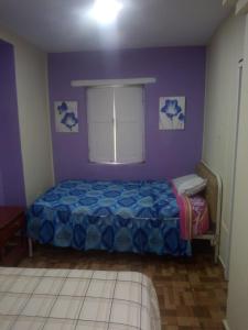 1 dormitorio con cama y ventana en Hotel tanta Wasi, en Quito