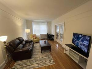 a living room with a leather couch and a flat screen tv at Fantastic stay for 4 – Heart of Hoboken! in Hoboken