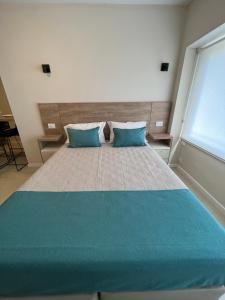 1 dormitorio con 1 cama grande y 2 almohadas azules en Departamento Rivadavia en Mar del Plata