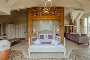 a bedroom with a bed with purple pillows and a couch at Sandburn Hall in York