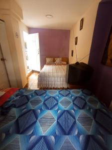 1 dormitorio con 2 camas y suelo azul en Hotel tanta Wasi, en Quito