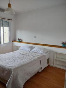 Habitación blanca con cama y ventana en URIBURU en Tandil