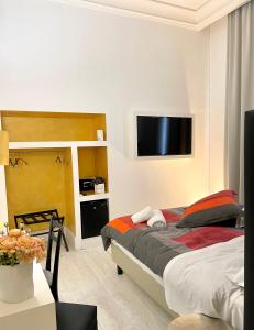 Schlafzimmer mit einem Bett und einem Flachbild-TV in der Unterkunft XENIA LUXURY ROOMS in Reggio di Calabria