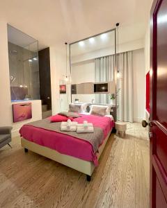 a bedroom with a large bed with two towels on it at XENIA LUXURY ROOMS in Reggio di Calabria