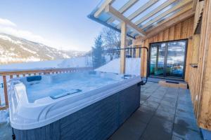 a hot tub on the deck of a house at Chalet Bavaria in Sankt Lorenzen ob Murau