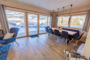 a dining room with a table and chairs and windows at Chalet Bavaria in Sankt Lorenzen ob Murau