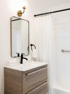a bathroom with a sink and a mirror and a tub at Laguna Beach Lodge in Laguna Beach