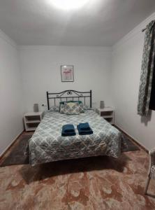 ein Schlafzimmer mit einem Bett mit zwei blauen Kissen darauf in der Unterkunft Casa Blanca w sercu Andaluzji / Finca / Village House in Montecorto