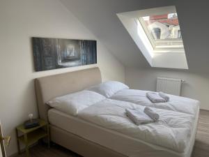 a bed with white sheets and towels on it at Dachterrasse für 4 Personen in Vienna